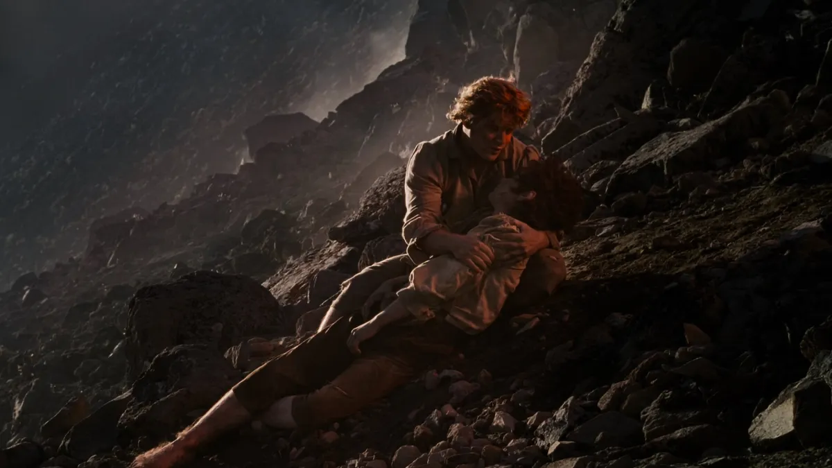 Secondary characters in film: Samwise Gamgee holds Frodo on the dark slope of Mount Doom in The Return of the King (2003)